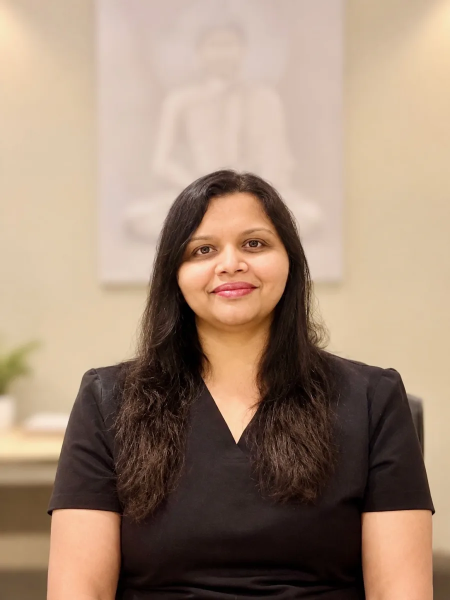 Portrait of the practitioner, a Registered Massage Therapist and Ayurvedic practitioner, seated in the clinic